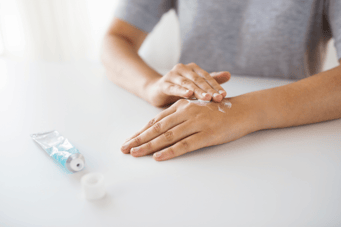 woman_applying_cream_on_hand-shutterstock_795969136